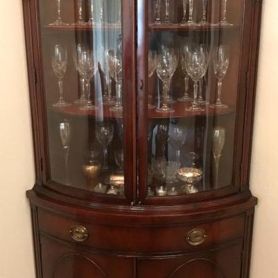 Antique corner display hutch with unique rounded front.