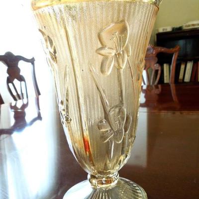 Close up of marigold carnival glass iris vase.
