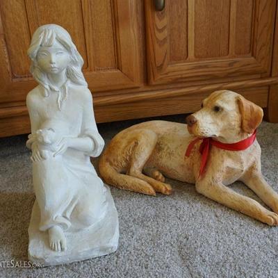 Two statues. One is a dog and another of a girl