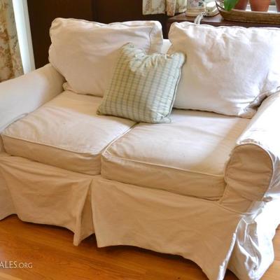 One of two Pottery Barn loveseats with slip covers