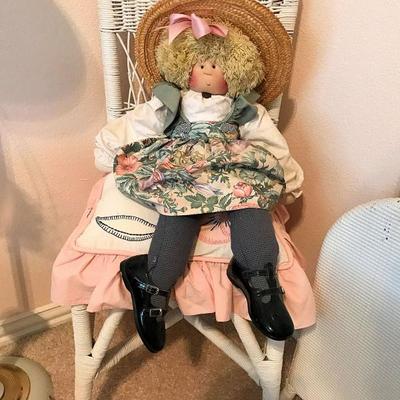 Cute, cute doll in a wicker side chair