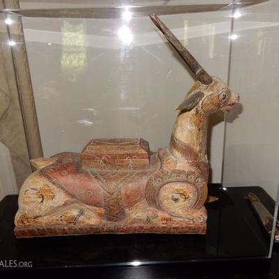 Lot # 101 /   Bali late 19-20 century Funerary statue of a kneeling horned animal. Carved wood and polychrome in the wood saddle is a...