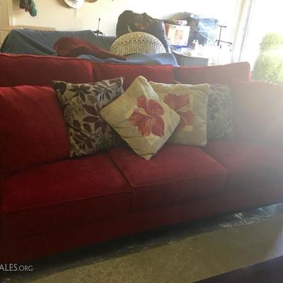 Red hide-a-bed couch with pillows