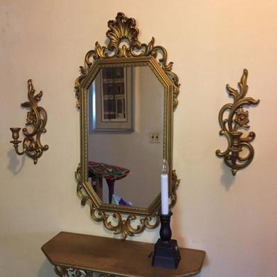 Brass sconces, framed mirror and shelf