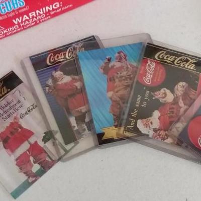 Variety of Coca-Cola items - White Polar bear with light and sound in red hat, trading cards for Coc