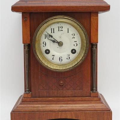 Junghans German mantle clock with walnut case. Has silver face with black enamel Arabic numerals. Black hour and minute hands, time and...