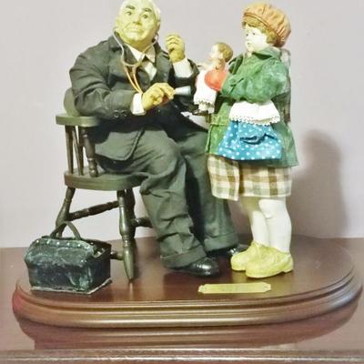 Norman Rockwell figuerine on wood base with plaque