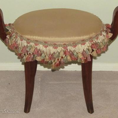 A Sweet Oval Roman Style Vanity Stool with Taffeta Upholstery and Tiered Tassel fringe