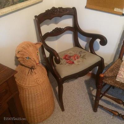 Woven wicker hamper of a kitty cat with glass marble eyes. Also, a needlepoint seated arm chair