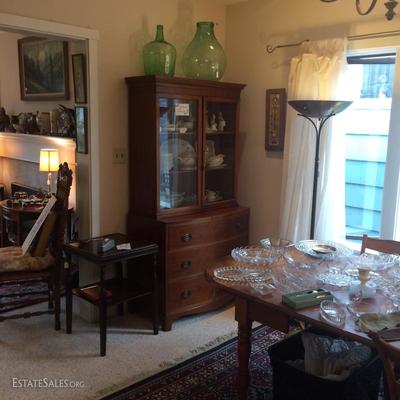 Dining room with two large green glass bottles on top of the China hutch