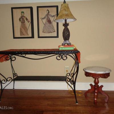 Wicker table with metal frame; small marble top table; framed Indonesian puppets; pineapple lamp