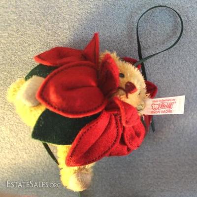 Steiff Poinsettia Bear Ornament 624 in blond  mohair.  He has jtd. arms and legs and a head that  will turn.  His eyes are black and a...