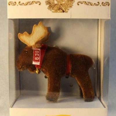 North American Exclusive.  A brown mohair moose  with felt air-brushed antlers.  A red velvet  ribbon around it's neck with hanging round...