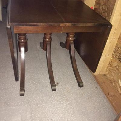 Dining table expands as legs roll apart