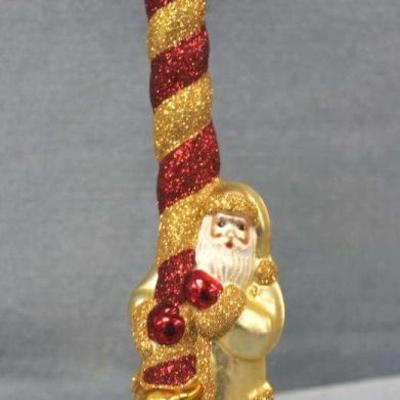 Patricia Breen "Peppermint Santa" red and gold  Christmas ornament.  Santa sliding down a  peppermint candy cane colored in...