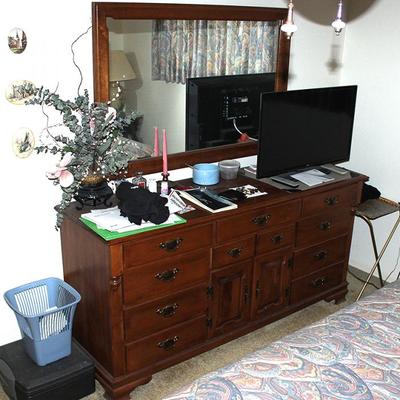 Dresser with mirror, TV, candlesticks, floral arrangements, TV tray