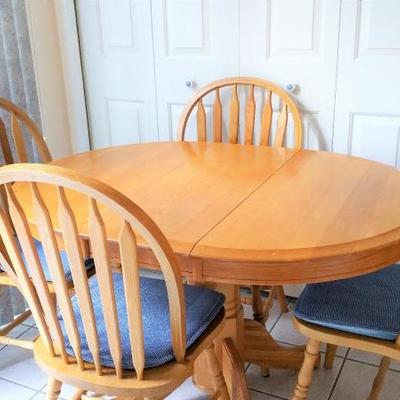 Oak round table with one leaf.  Makes it oval and accomodates the four matching oak windsor chairs. 
