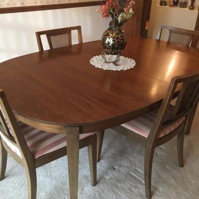 Lovely mid-century dining set with hidden leaves, and 2 extra coordinating chairs (6 in all). pads included
