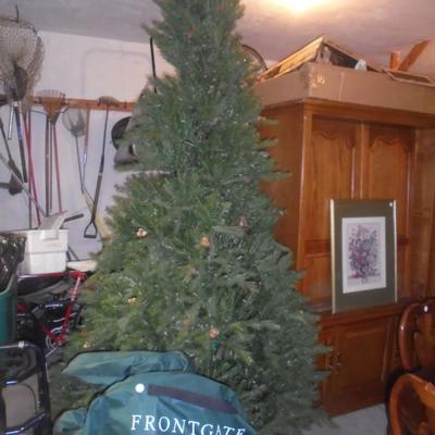 9' Pre-Lit by Front Gate. Tree folds down and can be put in it's protective bag and wheeled away for storage.