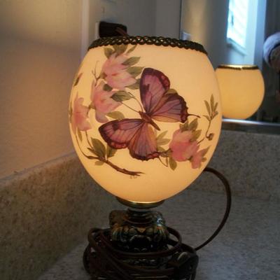 Hand painted Ostrich Egg made into a lamp, shown with light on.
