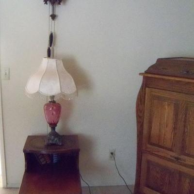 Cranberry lamp, coffee and end tables, and silk flower arrangements.