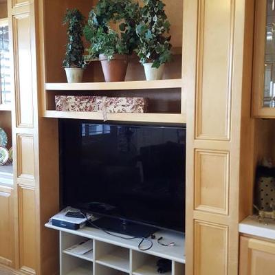 Flat screen TV, shelvess and decorative items.
