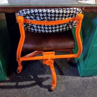 Orange metal desk chair with green filing cabinets and desk top