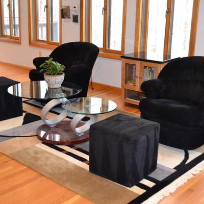 Pair of black ultrasuede swivel chairs with ottomans