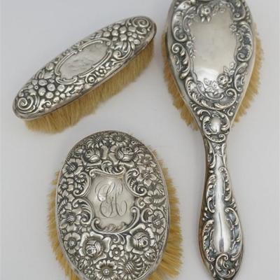 Three Antique American Sterling Silver Brushes. All with Floral Repousse. Two hairbrushes, 1 clothes brush
