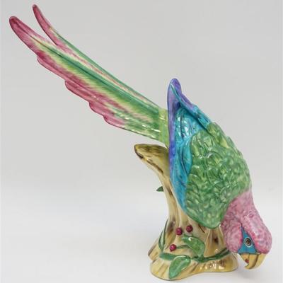 Signed Limited Edition Lynn Chase Porcelain Macaw Sculpture. A colorful Macaw is depicted perched and eating berries. The piece is signed...