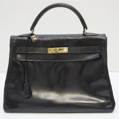 Vintage Classic Hermes Box Sellier Kelly Bag in Noir Calfskin. This bag features a rolled leather top handle and polished gold hardware....