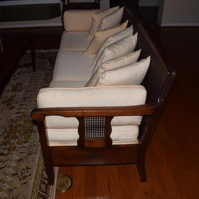 Cane backed sofa with upholstered cushions. Back of sofa needs repair. Priced accordingly. Does have other matching pieces that are in...
