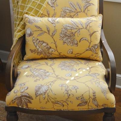 Designer armchair with scrolled arms and yellow botanical upholstery