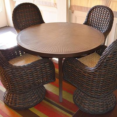 Laneventure iron patio table with 4 ratan style swivel chairs with floral upholstery
