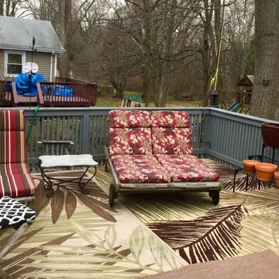Patio deck furniture including 2 chairs, 1 single chaise lounge, 1 double chaise lounge, marble-top wrought iron table, outdoor rugs