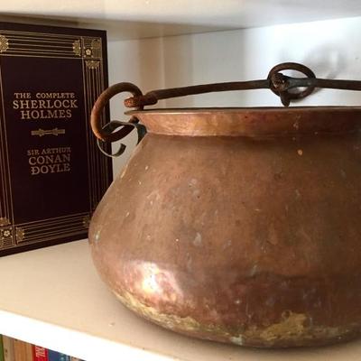 Vintage copper pots, collection of leather-bound classic book titles.