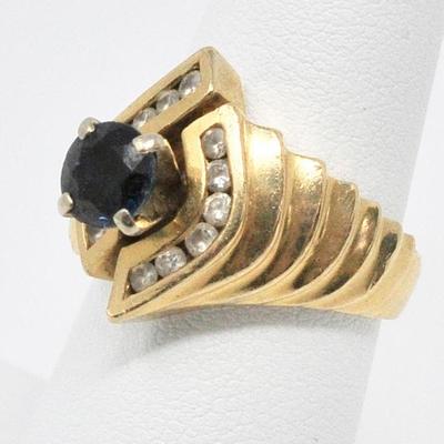 14k cocktail ring with blue center stone, and channel-set diamonds.