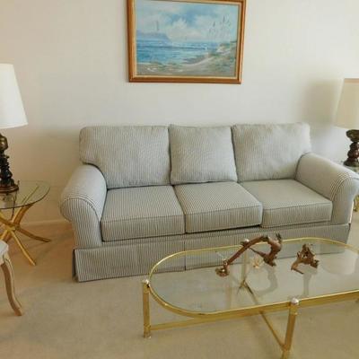 sofa with blue and white strips and brass and glass end table set