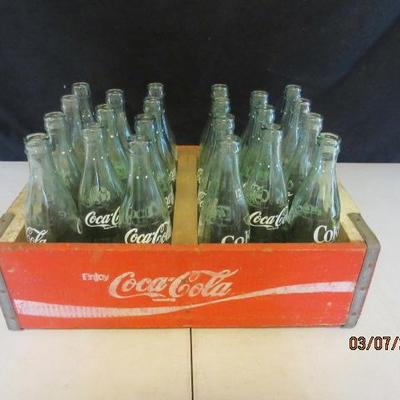 Red vintage Coca Cola soda crate with glass bottles. 
