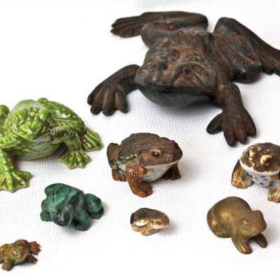 collection of frog figurines made from various materials including metal and ceramic