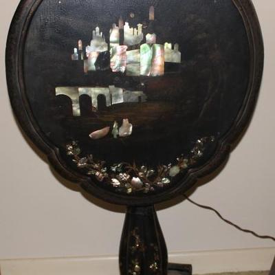 Tilt top black lacquer table with inlaid mother of pearl, bottom has severe damage.