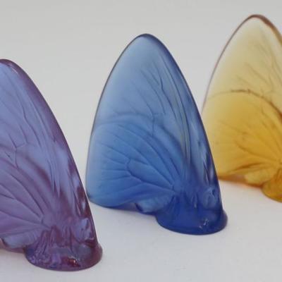 Three Lalique Crystal Colored Papillon / Butterflies. Sapphire Blue, Amber and Purple. All signed, in good condition. Each 2 1/4