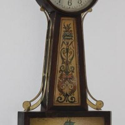 Antique Federal Style E Ingraham Mahogany 8 Day Time and Strike Banjo Clock with Eagle Finial.  This clock has a rectangular base...