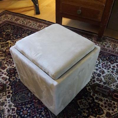 Storage ottoman with a cover that flips over and opens to make a tabletop. Handy!
