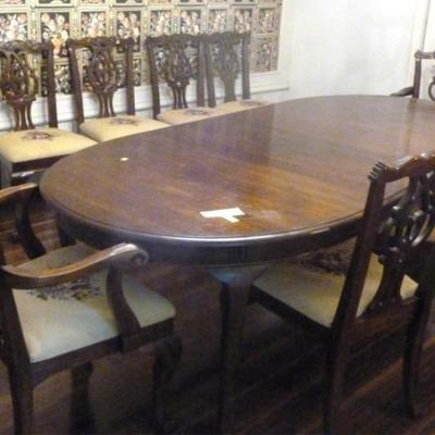 Solid wood dining table with 8 Chippendale style  needlepoint chairs and three leaves, 64