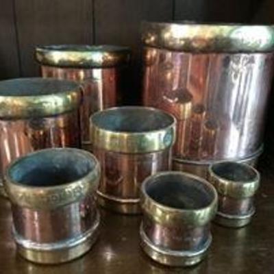 Seven (7) yellow and red copper measuring cups in Indian 