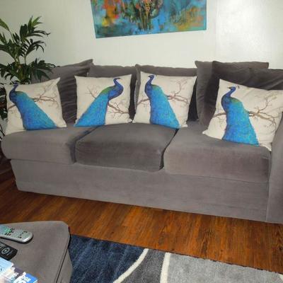 Two grey soft fabric upholstered Bassett couch with 6 pillows. Set of four peacock throws sold separately
