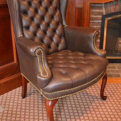 One of a pair of leather wing back chairs