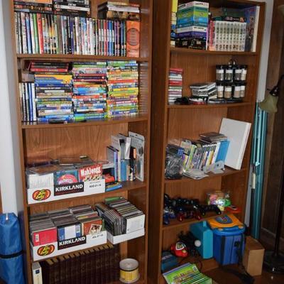 Shelving unit, VHS tapes, DVDs, video game remotes, books 