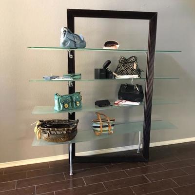 Floating glass shelf - filled with coach bags and wallets 